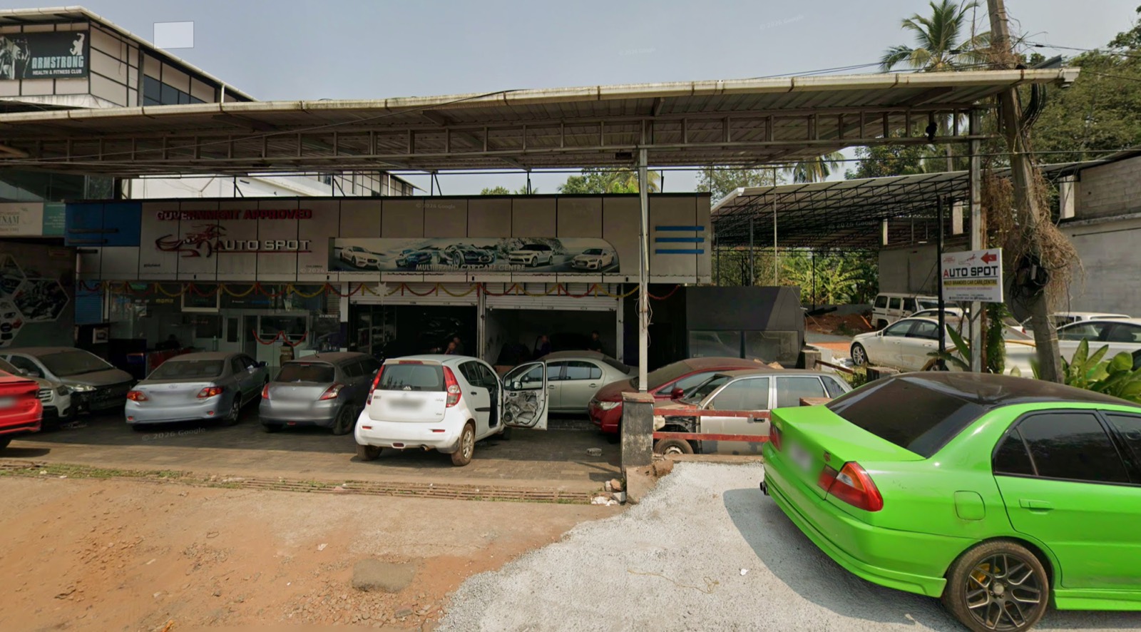 Street view of the Auto Spot Malappuram workshop on the NH 66 bypass with cars parked outside