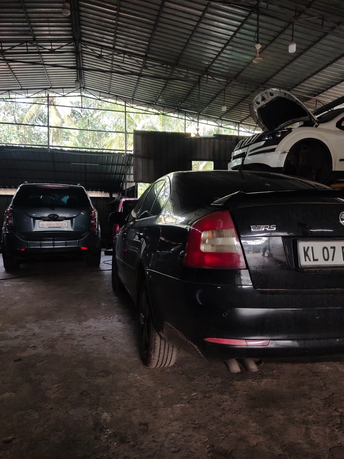 A Skoda Octavia vRS and a Ford Endeavour in the workshop with an SUV up on the lift behind them